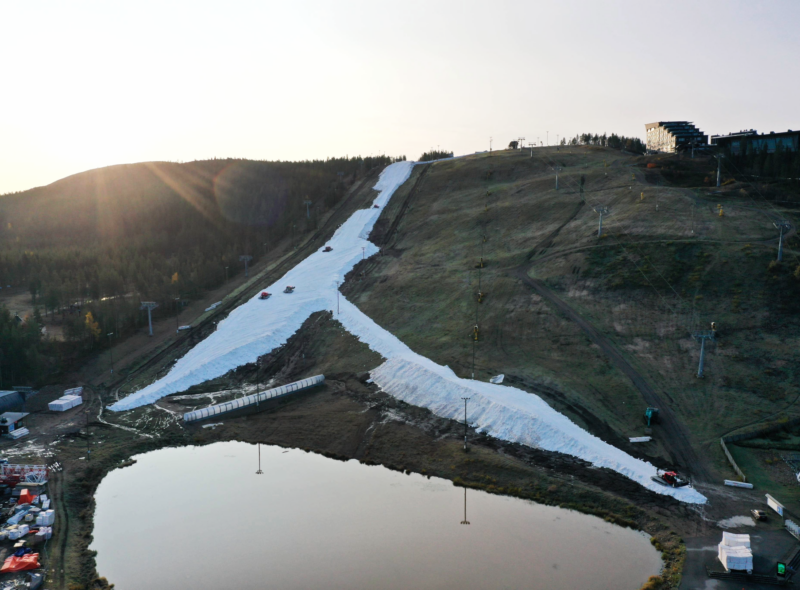 Aerial view of a snow-covered ski slope surrounded by snow-free terrain at Levi ski resort in Finnish Lapland.